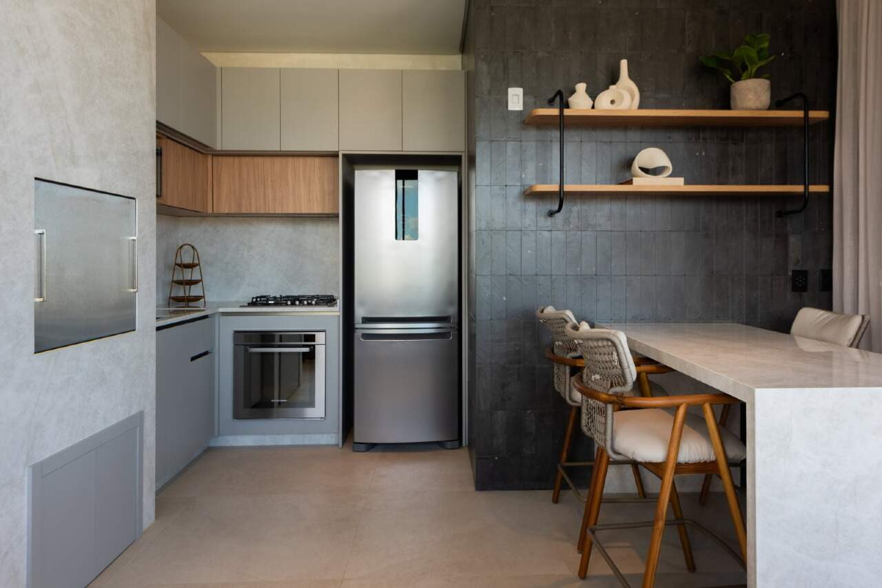 Cozinha gourmet com forno, cooktop e bancada de pedra