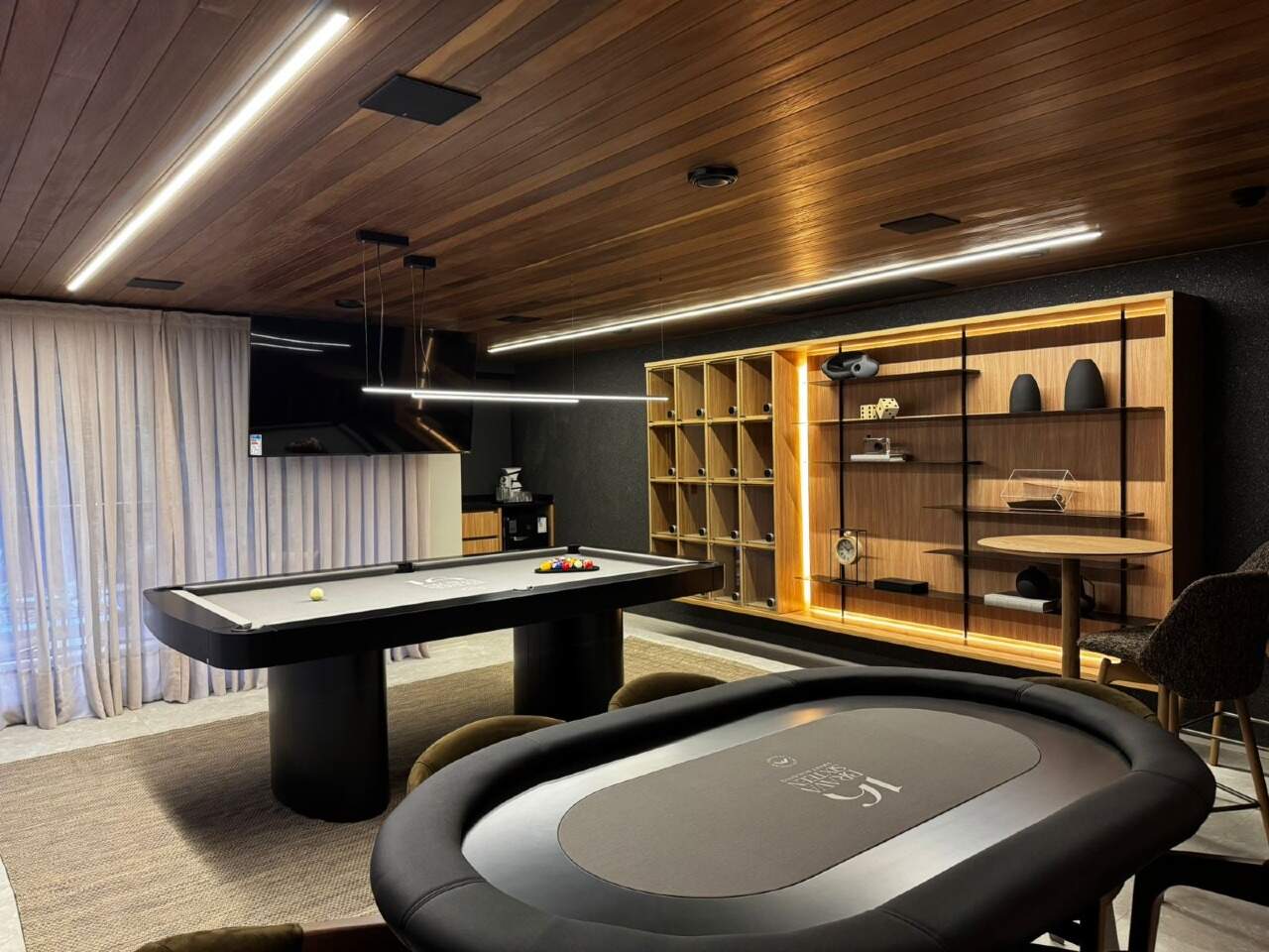 Sala de jogos com mesa de carteado e mesa de air hockey