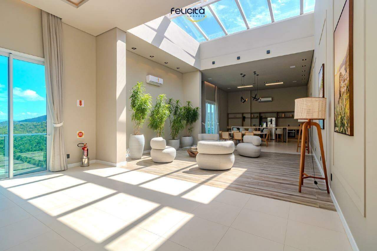 Lounge com claraboia, poltronas e jardim interno