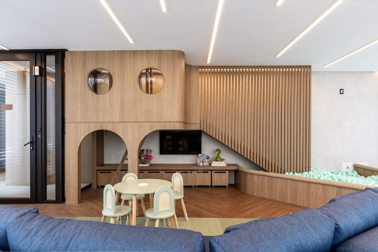 Kids club com casinha de madeira, piscina de bolinhas e televisão