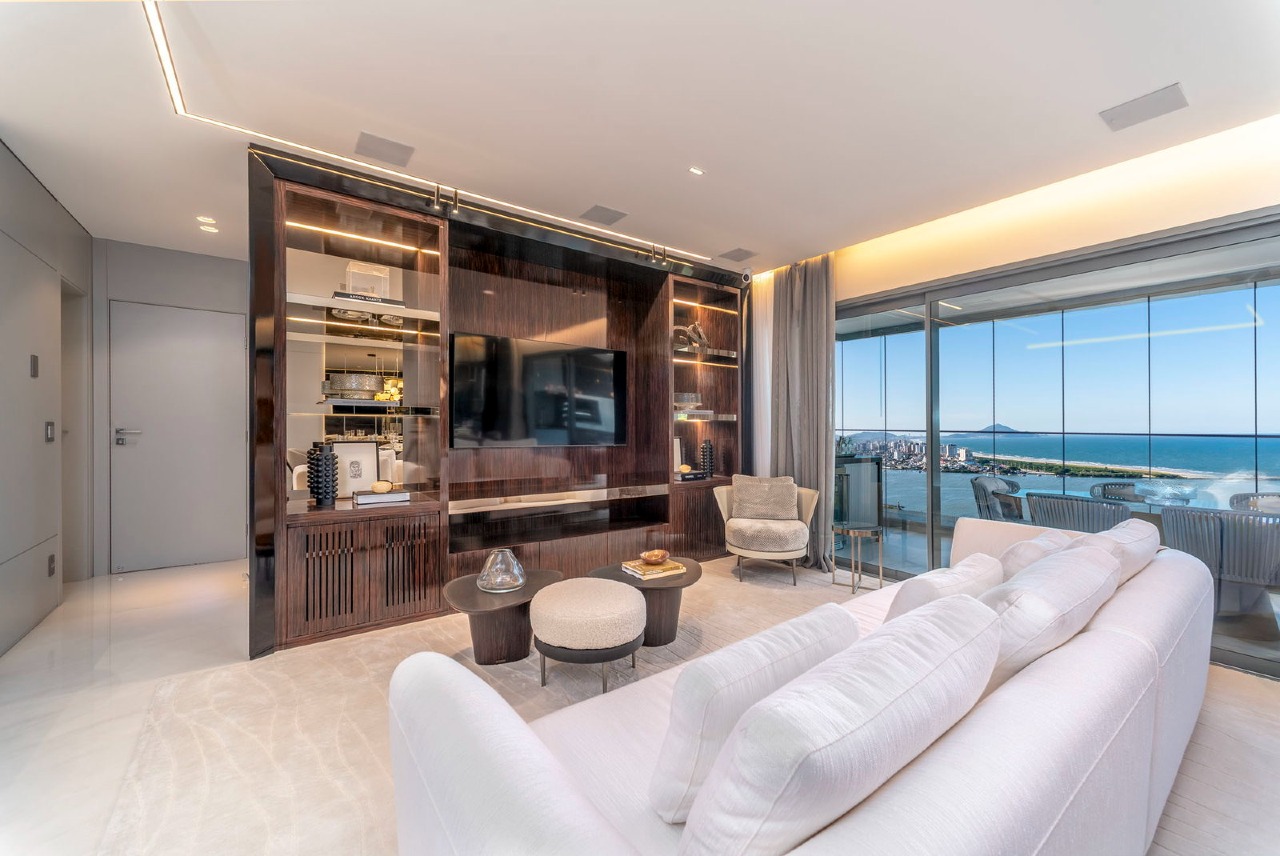 Estar do apartamento decorado, com painel de madeira e vista