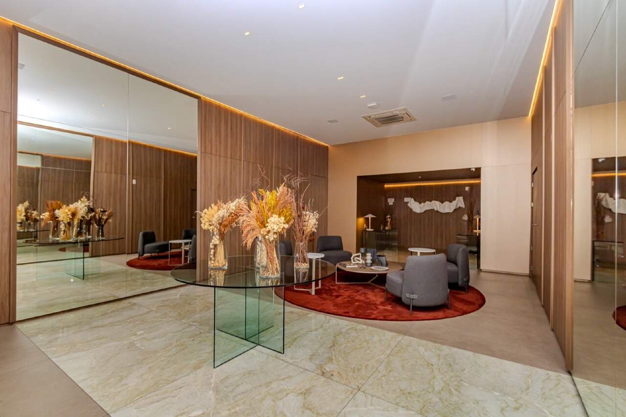 Hall de entrada decorado, com poltronas e arranjos
