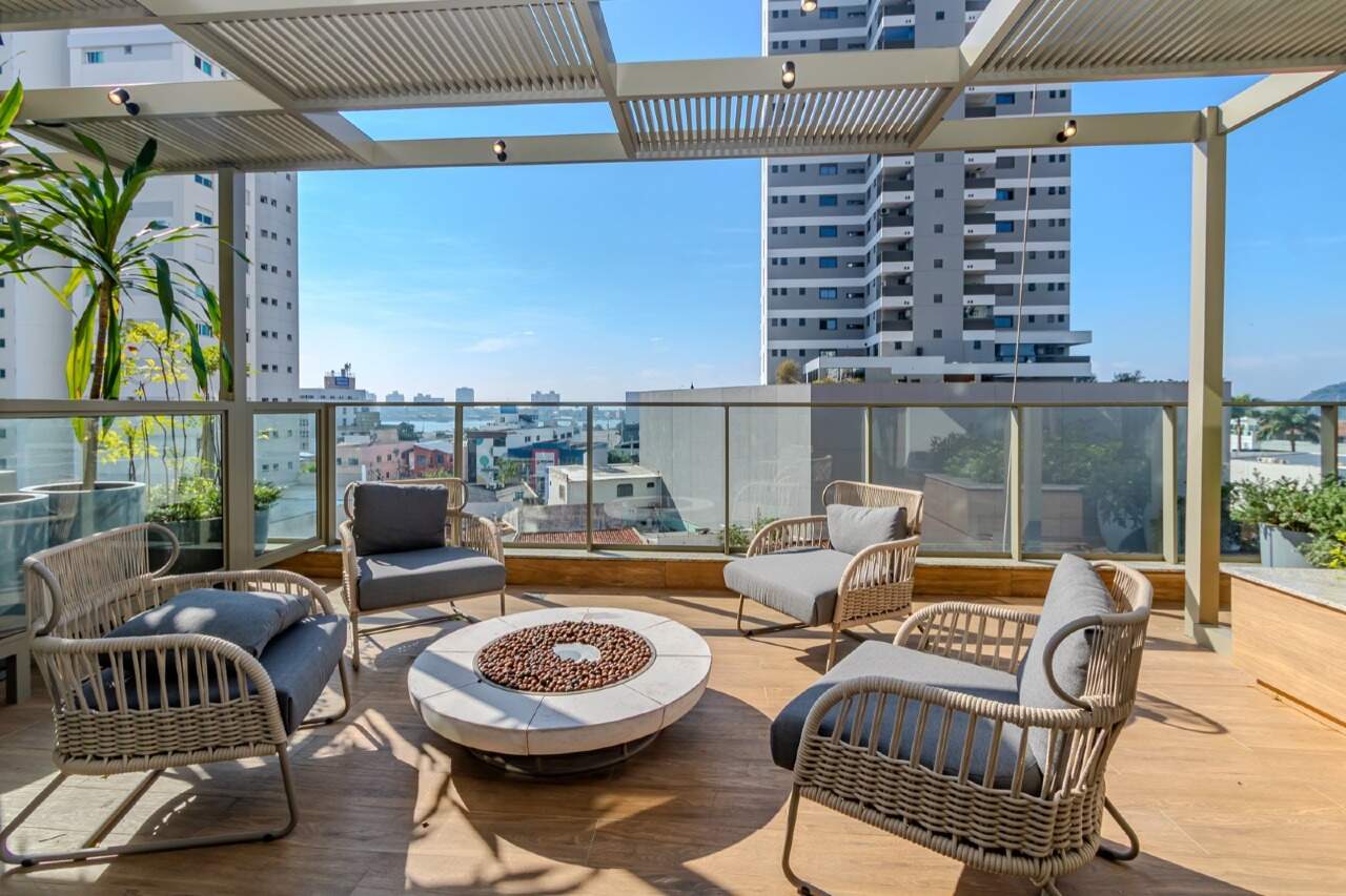 Terraço com poltronas, mesa de fogo e pergolado