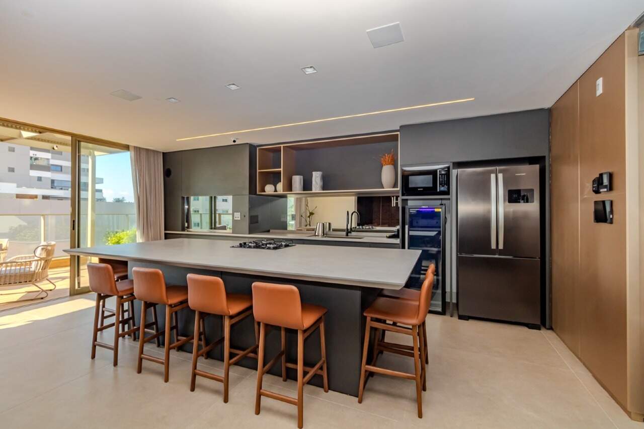 Cozinha gourmet com ilha, cooktop e banquetas