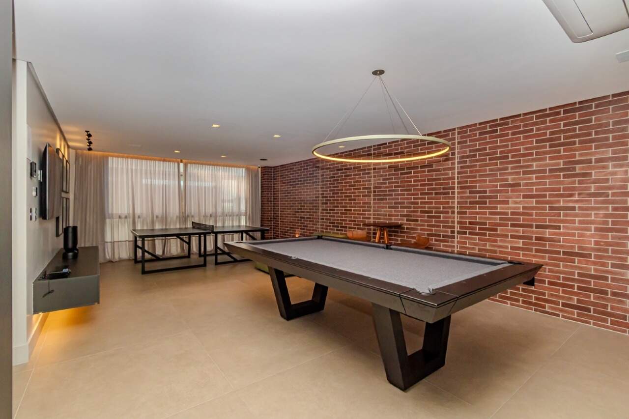 Sala de jogos com mesa de sinuca e pingue-pongue