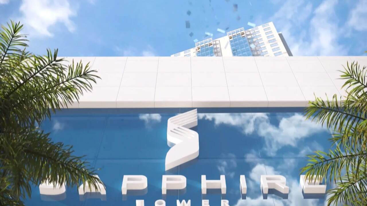 Letreiro do Sapphire Tower no embasamento, entre palmeiras (imagem ilustrativa)