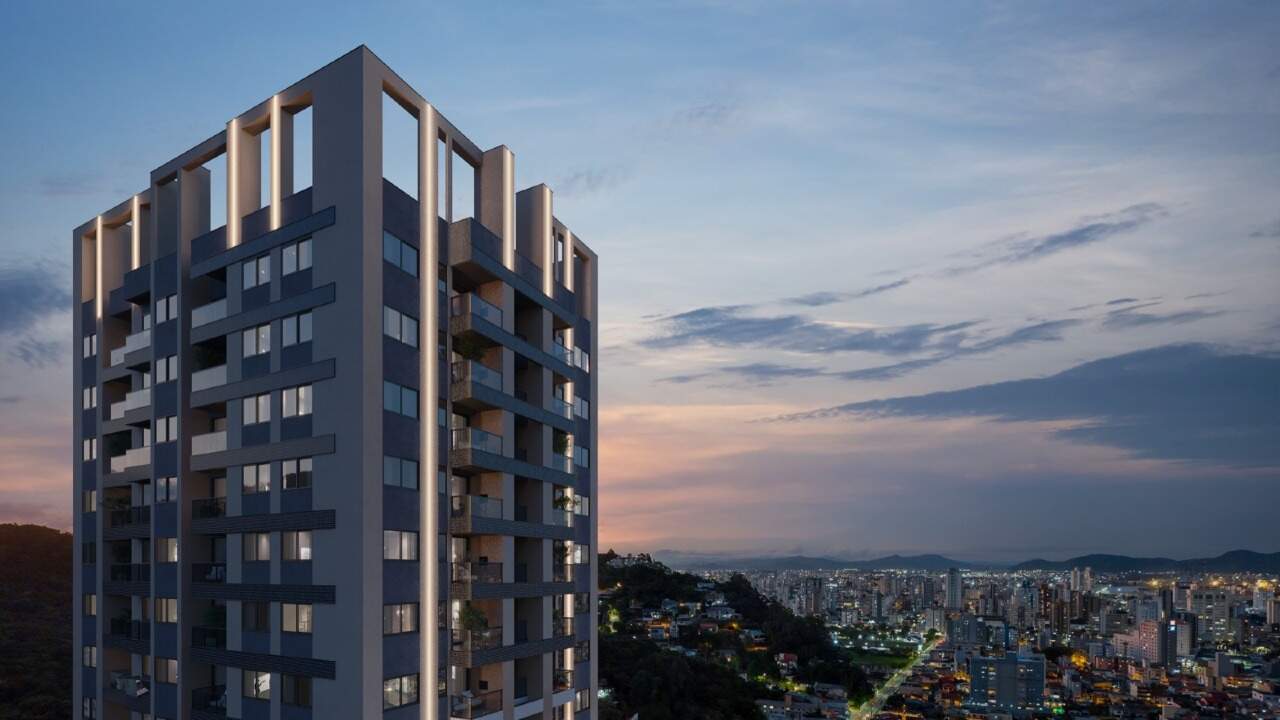 Coroamento iluminado da torre, com a cidade ao fundo (imagem ilustrativa)