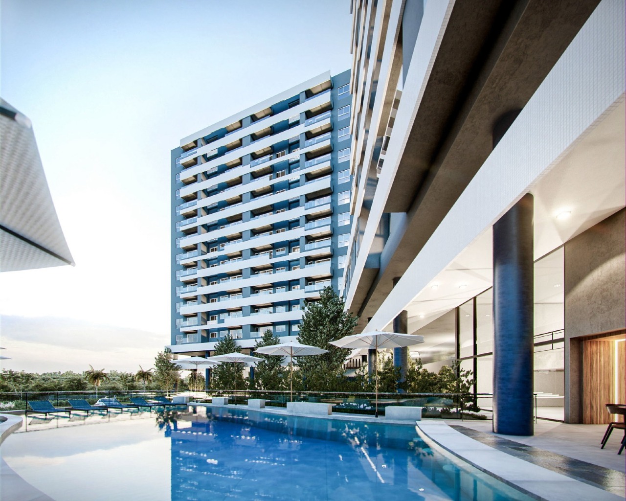 Piscina com guarda-sóis ao pé da torre (imagem ilustrativa)