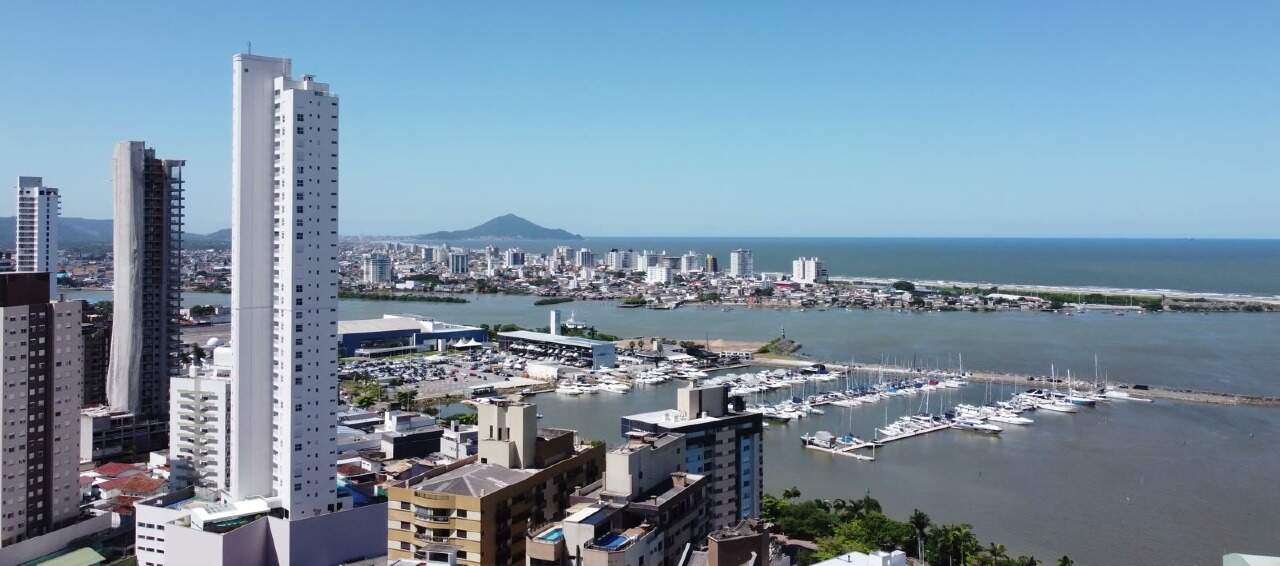 Vista real por drone no terreno: Marina Itajaí e a barra entre prédios vizinhos