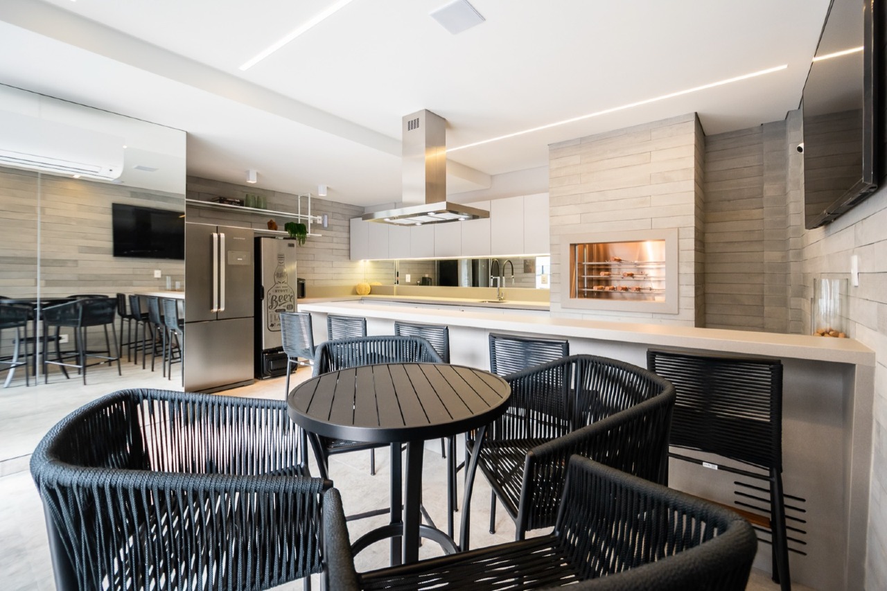 Espaço gourmet com mesas e churrasqueira