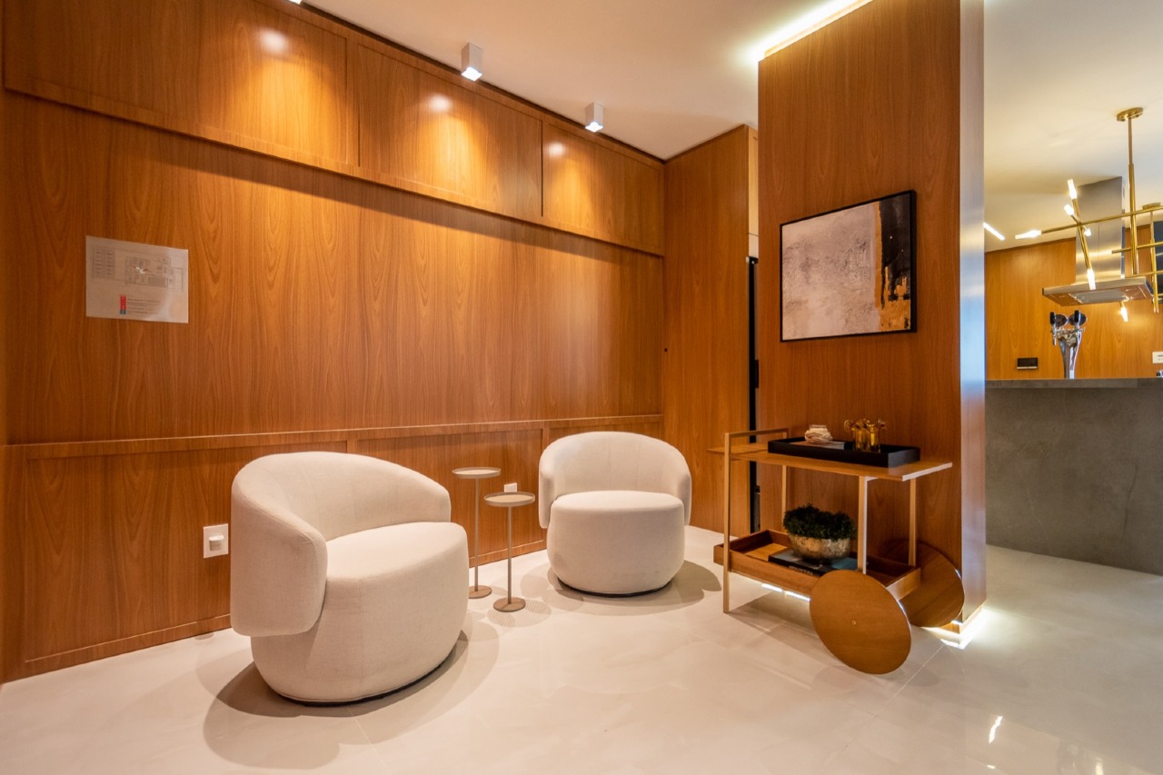 Estar com poltronas e painel de madeira