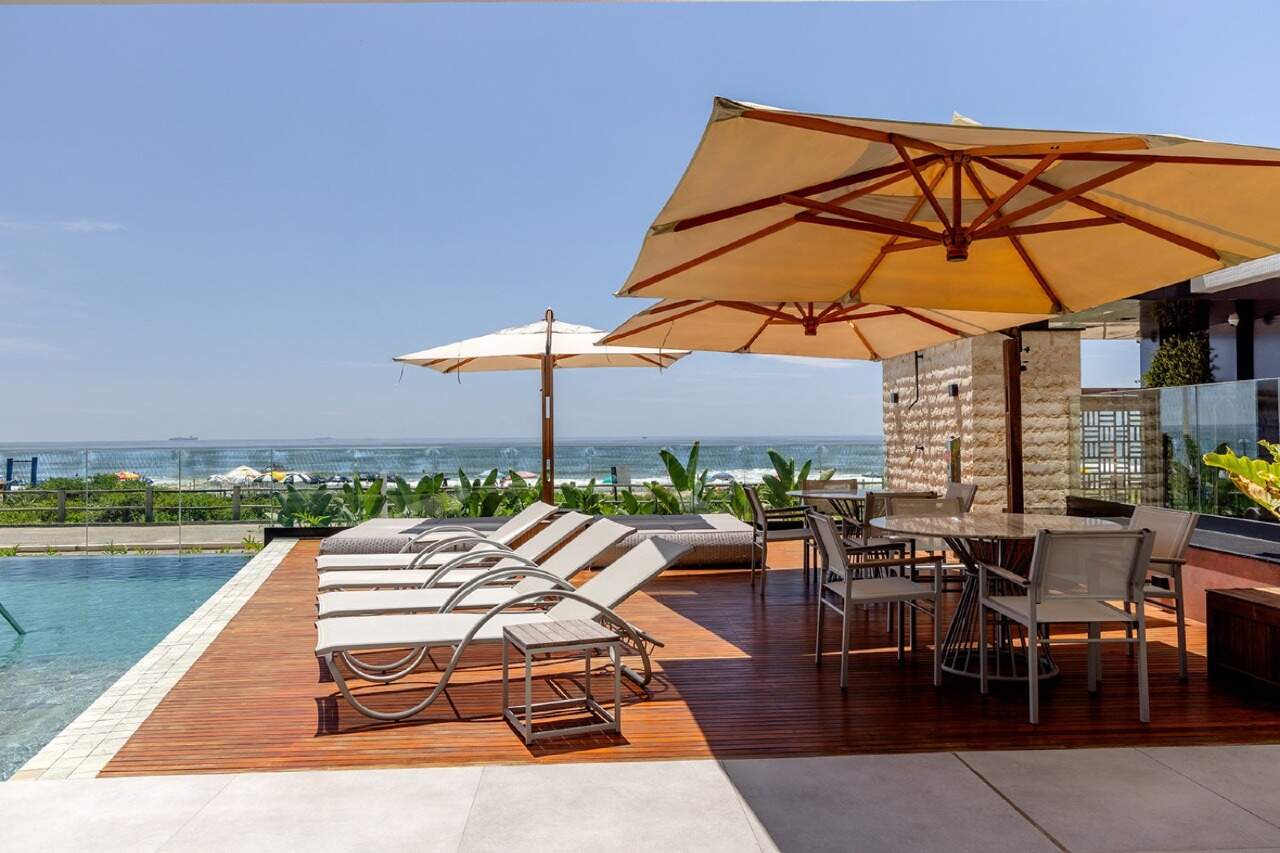 Apartamento à venda no Praia Brava: Deck com guarda-sóis e espreguiçadeiras de frente para a praia