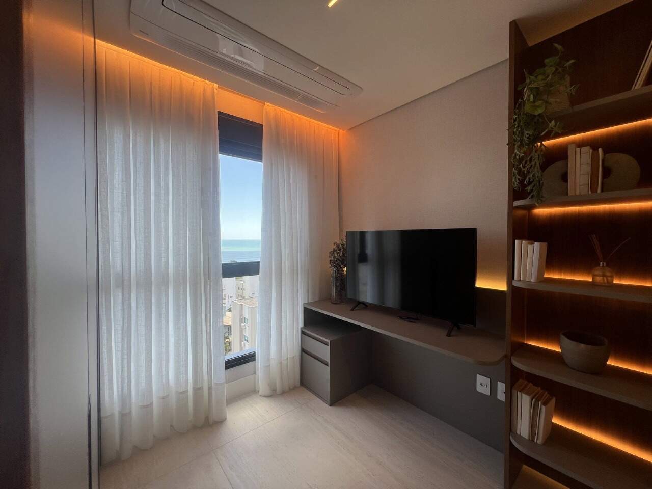 Apartamento à venda no Praia Brava: Estar do decorado com TV e janela para o mar (outra unidade)