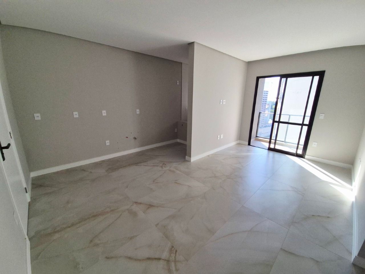 Apartamento à venda no Praia Brava: Living do apartamento de 54,63 m² com porta de vidro para a sacada e luz da manhã