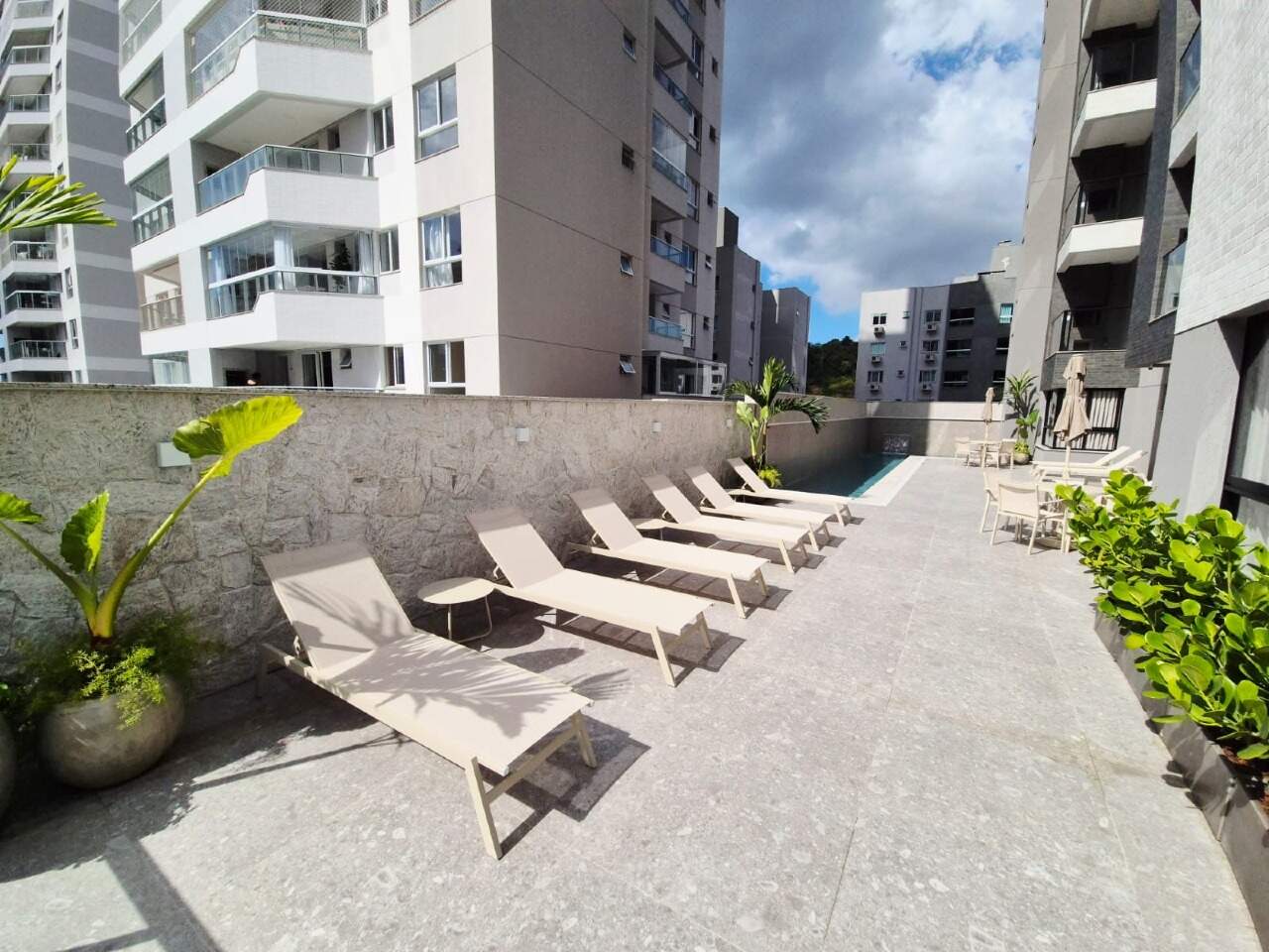 Apartamento à venda no Praia Brava: Deck com espreguiçadeiras ao lado da piscina com raia
