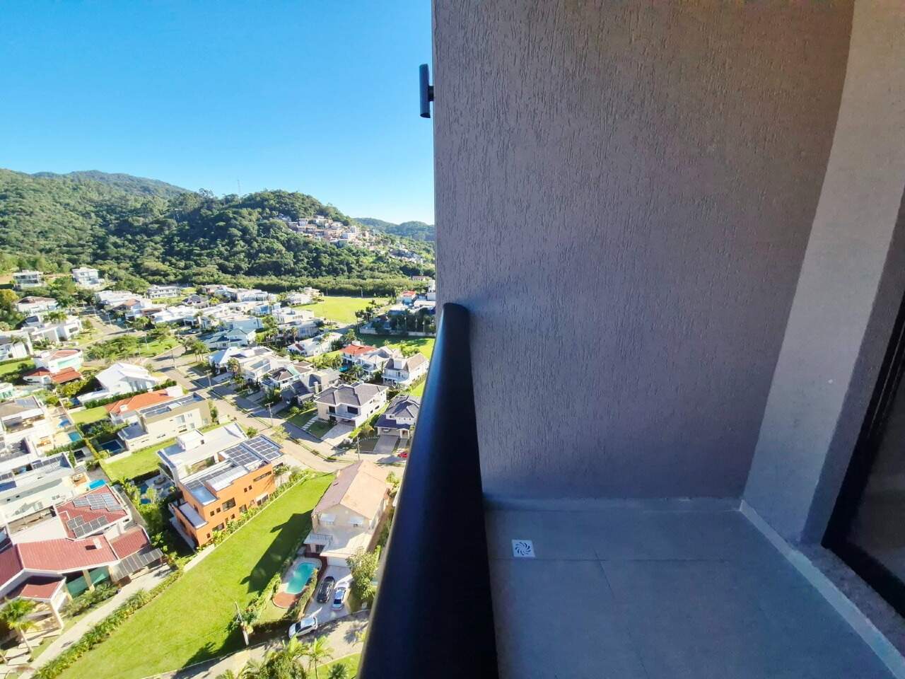 Apartamento à venda no Praia Brava: Vista lateral da sacada para os morros e um condomínio de casas