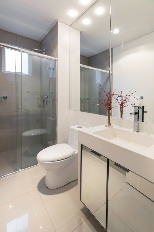 Apartamento à venda no Centro: Banheiro de suíte com box de vidro, bancada branca e espelho