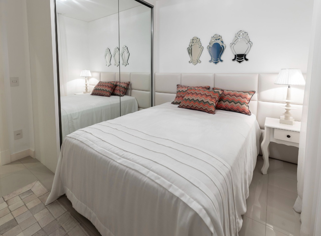 Apartamento à venda no Centro: Suíte com cabeceira estofada, espelhos venezianos e armário espelhado