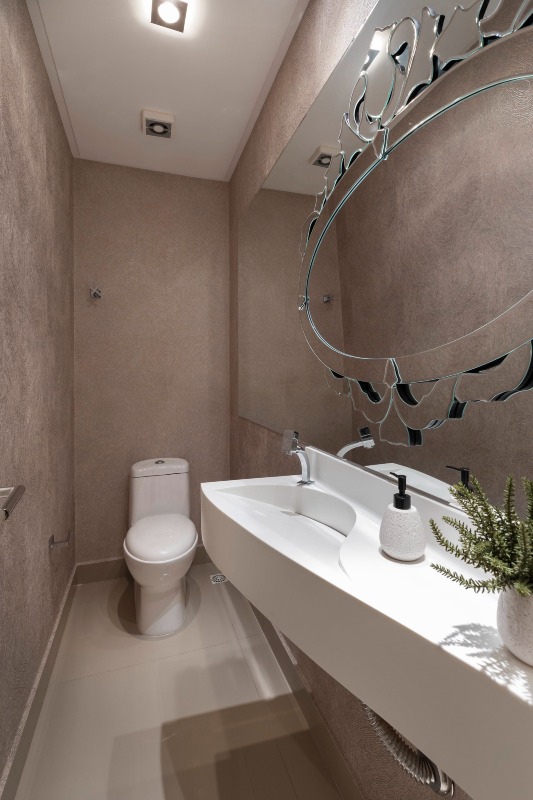 Apartamento à venda no Centro: Lavabo com parede texturizada, bancada com cuba esculpida e espelho decorado