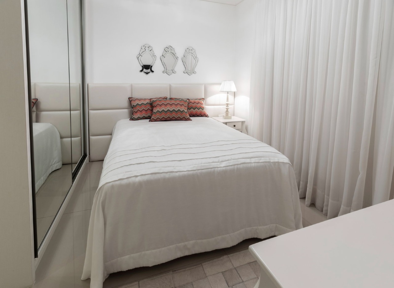 Apartamento à venda no Centro: Outro ângulo da suíte, com cortinas claras e armário de portas espelhadas
