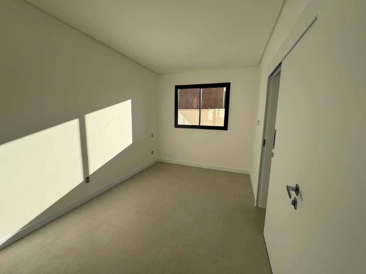 Apartamento à venda no Centro: Suíte com janela e luz natural à tarde