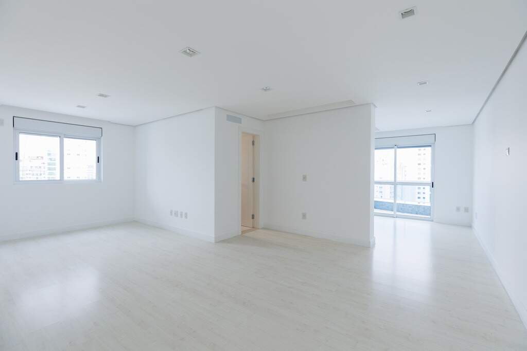Apartamento à venda no Centro: Ambiente amplo com piso laminado, janela e porta para a sacada