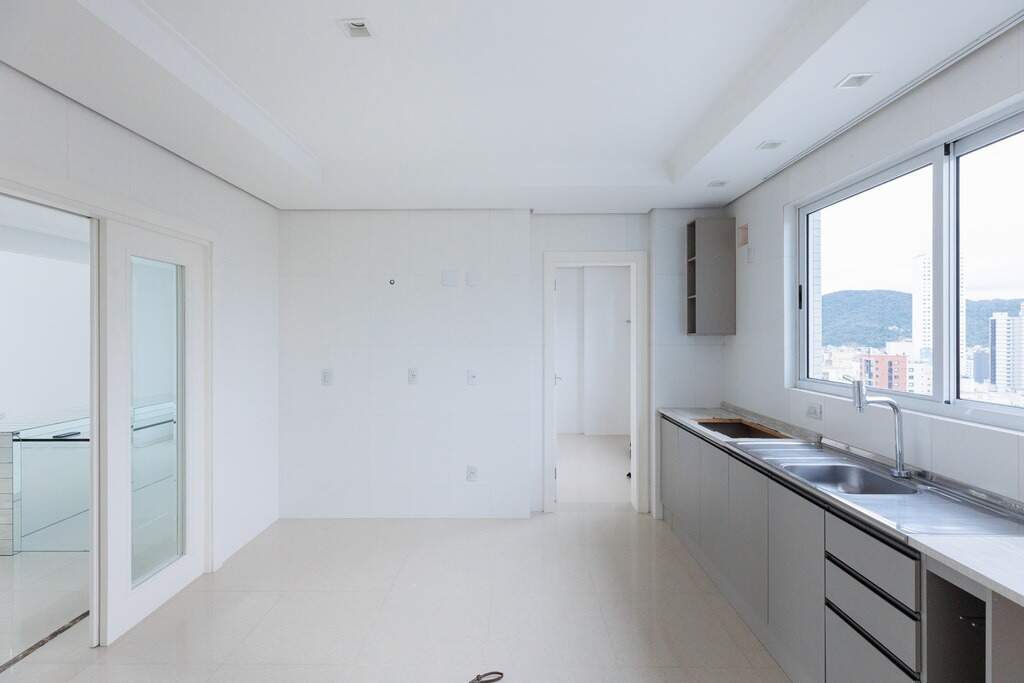 Apartamento à venda no Centro: Cozinha com bancada, pia em inox e janela ampla