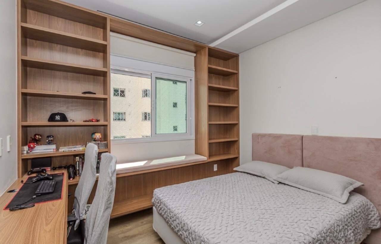 Apartamento à venda no Centro: Quarto com cabeceira estofada, bancada de estudo e estantes