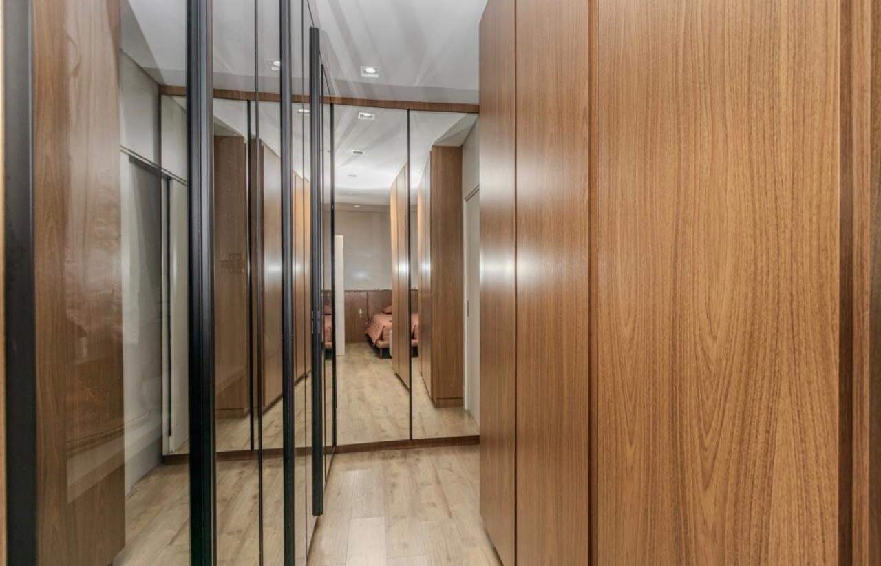 Apartamento à venda no Centro: Closet com armários de madeira e portas espelhadas