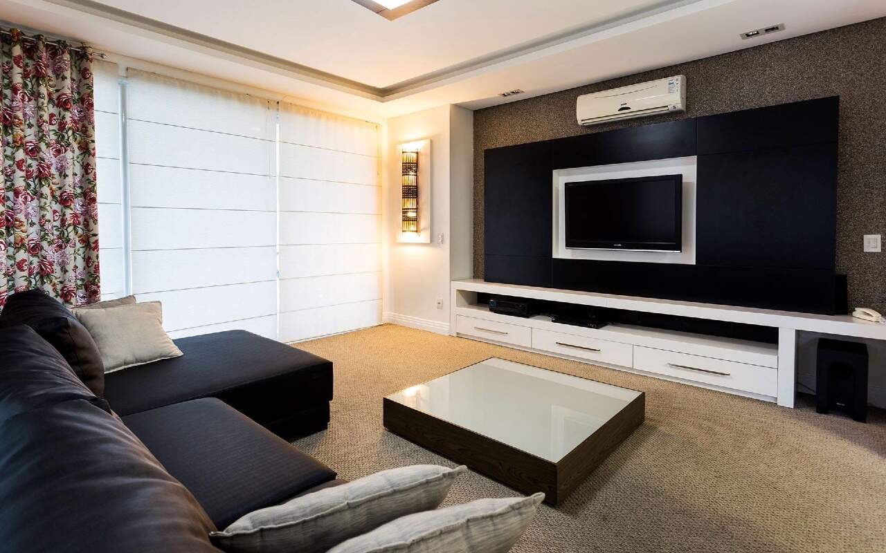 Apartamento à venda no Centro: Sala de TV com sofá em L, painel e televisão