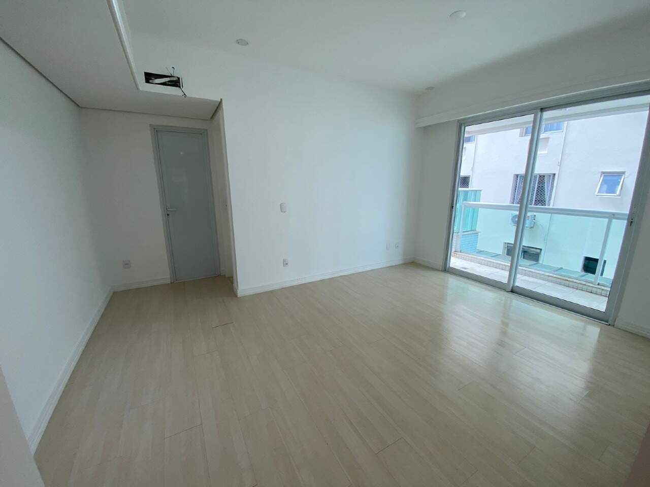 Apartamento à venda no Centro: Suíte com piso laminado, porta do banheiro e porta de correr para a sacada