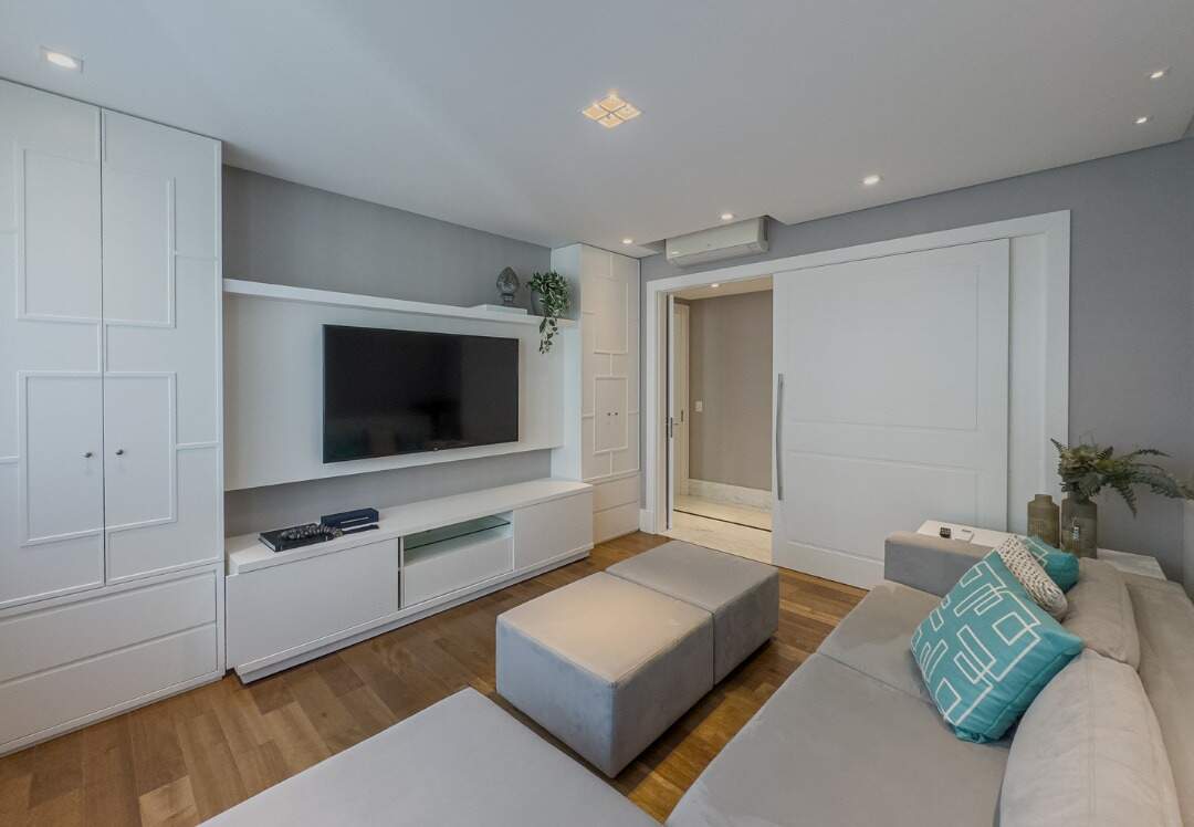Apartamento à venda no Centro: Sala de TV com sofá em L e painel com armários