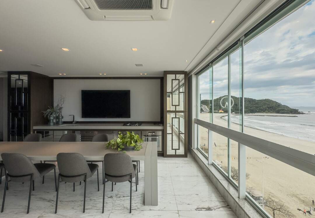 Apartamento à venda no Centro: Sacada envidraçada com mesa, bancada gourmet e vista para a roda-gigante da Barra Norte