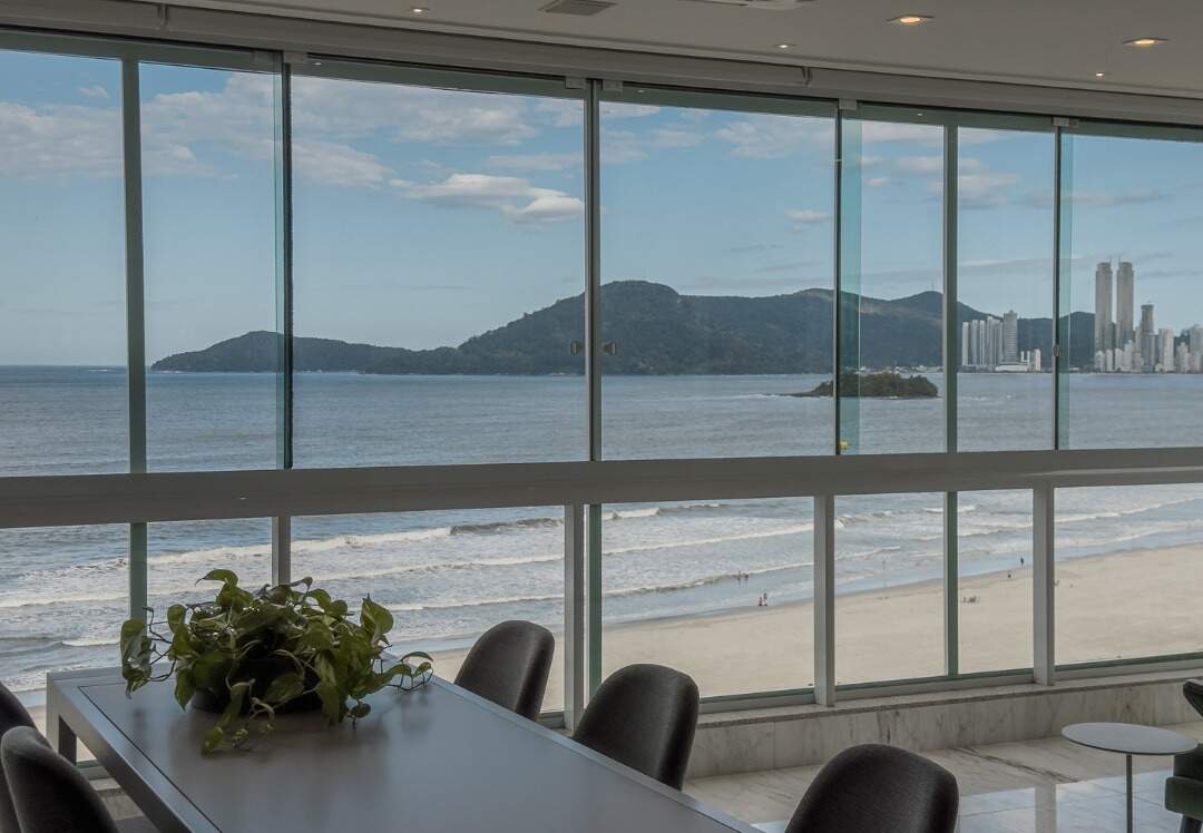Apartamento à venda no Centro: Mesa de jantar na sacada envidraçada, de frente para o mar, no Edifício Metrópolis