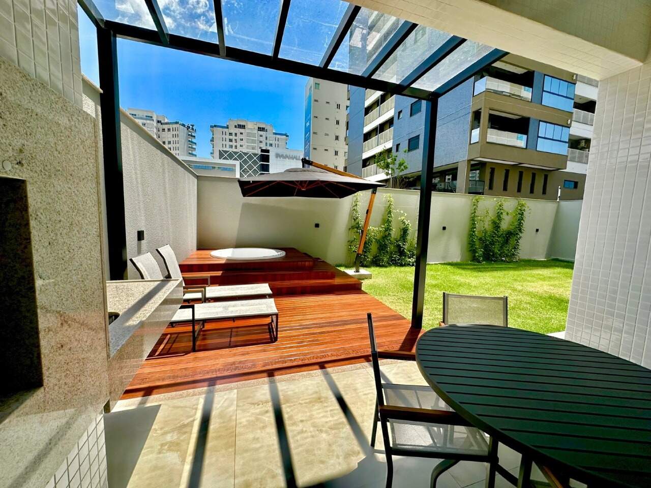 Apartamento diferenciado à venda no Praia Brava: Deck do garden decorado com pergolado de vidro, mesa externa e spa com hidromassagem