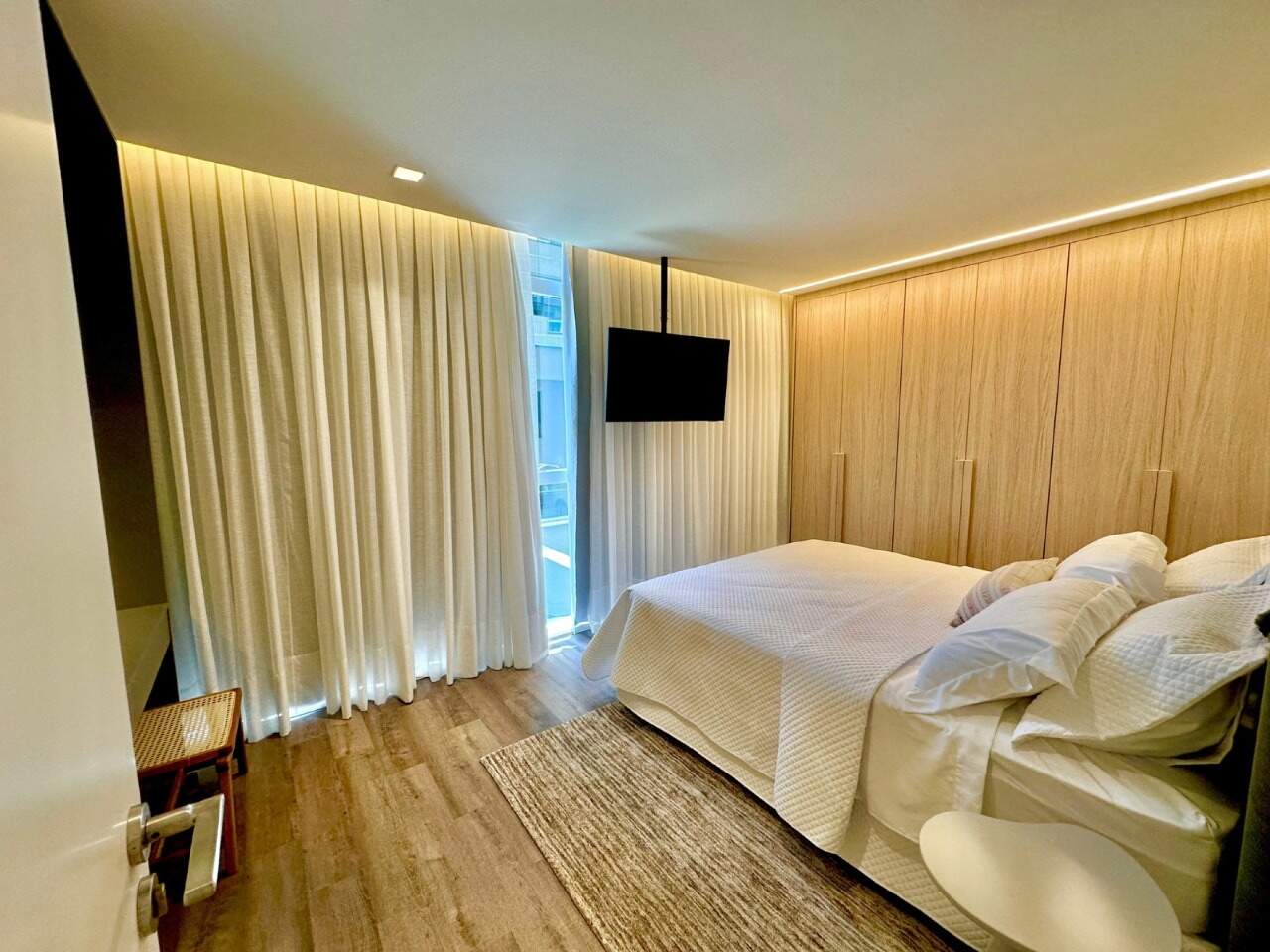 Apartamento diferenciado à venda no Praia Brava: Suíte com armários em madeira, TV e cortinas