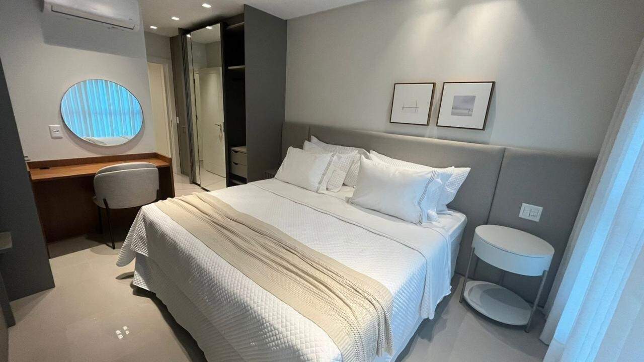Apartamento à venda no Pioneiros: Suíte com escrivaninha, espelho redondo e ar-condicionado