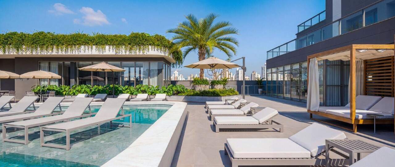 Apartamento diferenciado à venda no Centro: Solário com espreguiçadeiras junto às piscinas do Luminare (imagem ilustrativa)
