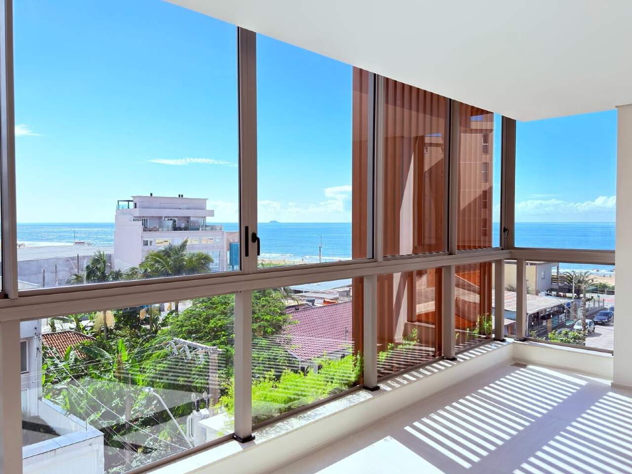 Apartamento à venda no Praia Brava: Living envidraçado com brise de madeira e vista para o mar, no In Exclusive Home