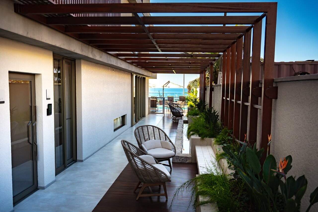 Apartamento à venda no Praia Brava: Varanda com pergolado de madeira e o mar ao fundo, na área comum