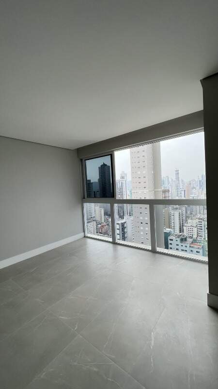 Apartamento à venda no Centro: Ambiente social com porcelanato e janela para os prédios do Centro