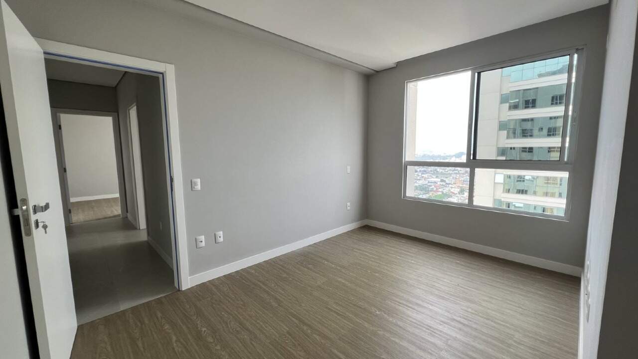 Apartamento à venda no Centro: Dormitório com piso vinílico e porta para o corredor da área íntima