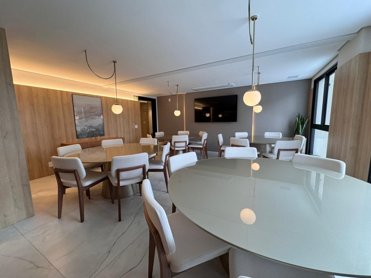 Apartamento à venda no Praia Brava: Salão de festas mobiliado, com mesa oval e painel de madeira