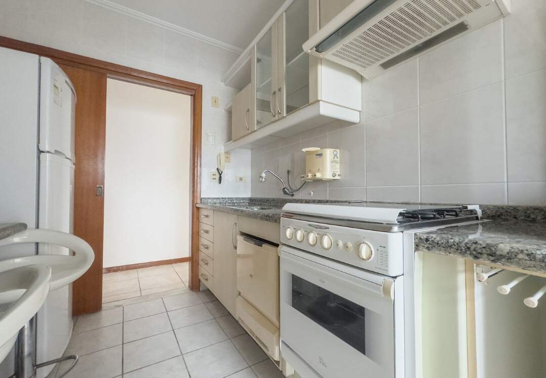 Apartamento à venda no Centro: Cozinha com fogão, armários e porta de correr