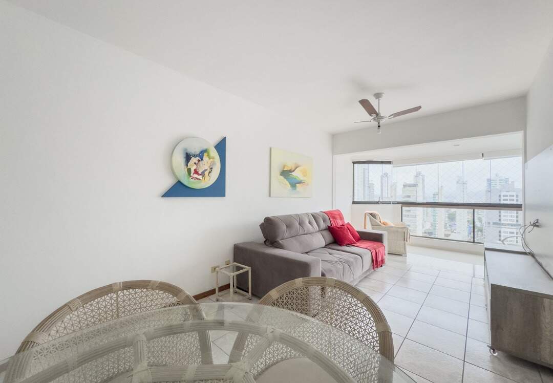 Apartamento à venda no Centro: Sala de jantar com mesa de vidro, com o sofá e a sacada ao fundo