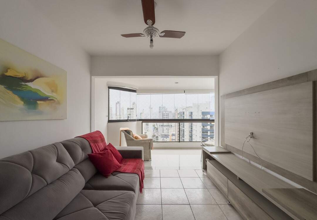 Apartamento à venda no Centro: Living do apartamento de 126 m² com sofá e a sacada envidraçada ao fundo, no Atlântico Shopping