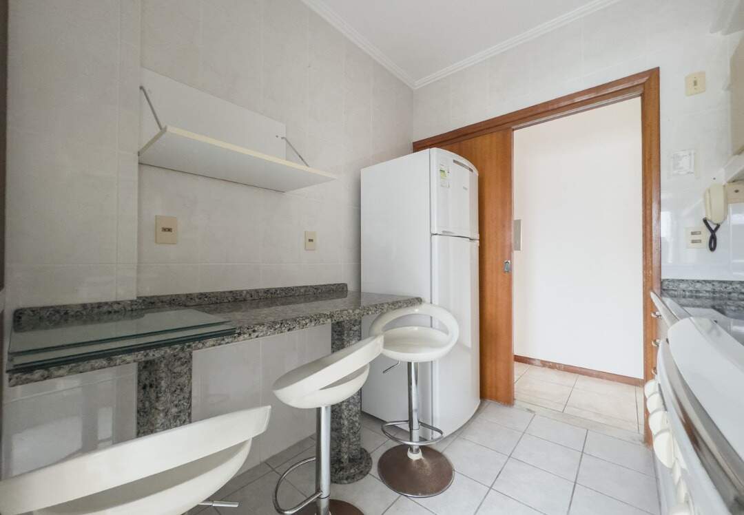 Apartamento à venda no Centro: Cozinha com bancada de granito, banquetas e geladeira