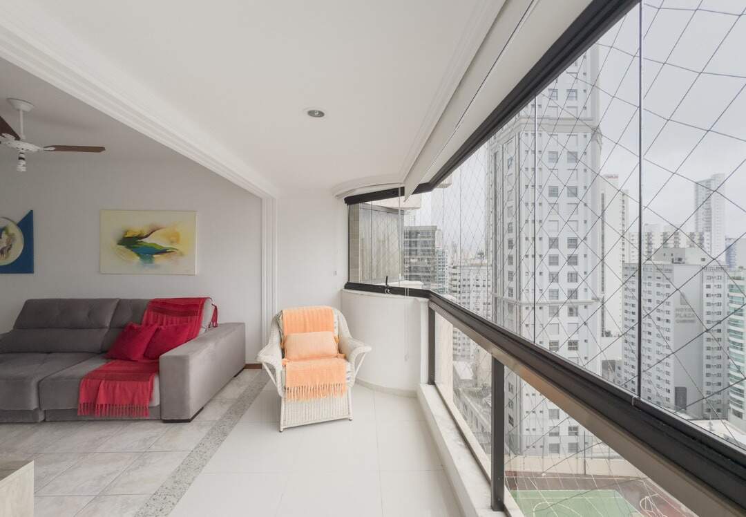 Apartamento à venda no Centro: Living integrado à sacada envidraçada, com a quadra do prédio embaixo