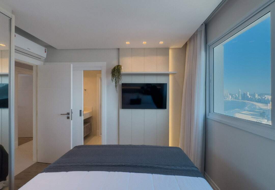 Apartamento à venda no Centro: Dormitório com painel de TV, ar-condicionado e janela para a praia