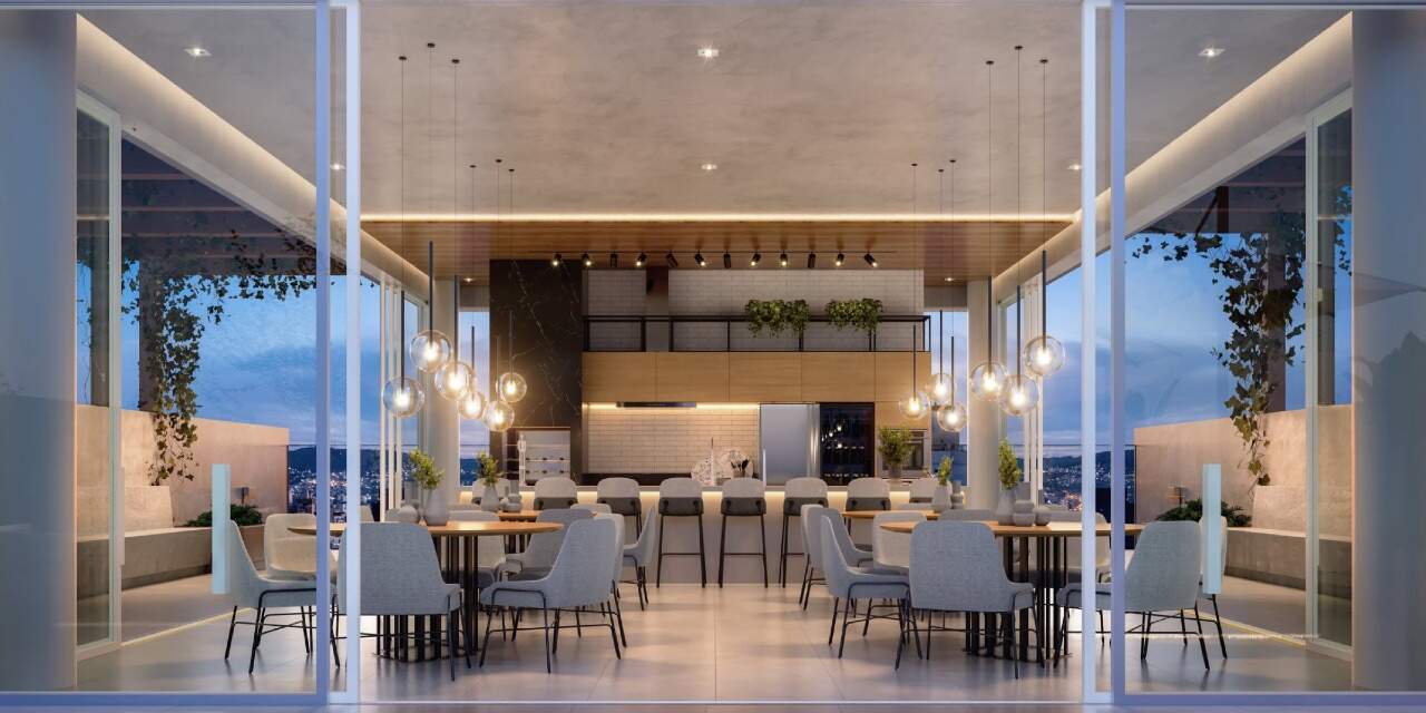 Apartamento à venda no Centro: Espaço gourmet com churrasqueira a carvão e mesas, ao anoitecer (imagem ilustrativa)